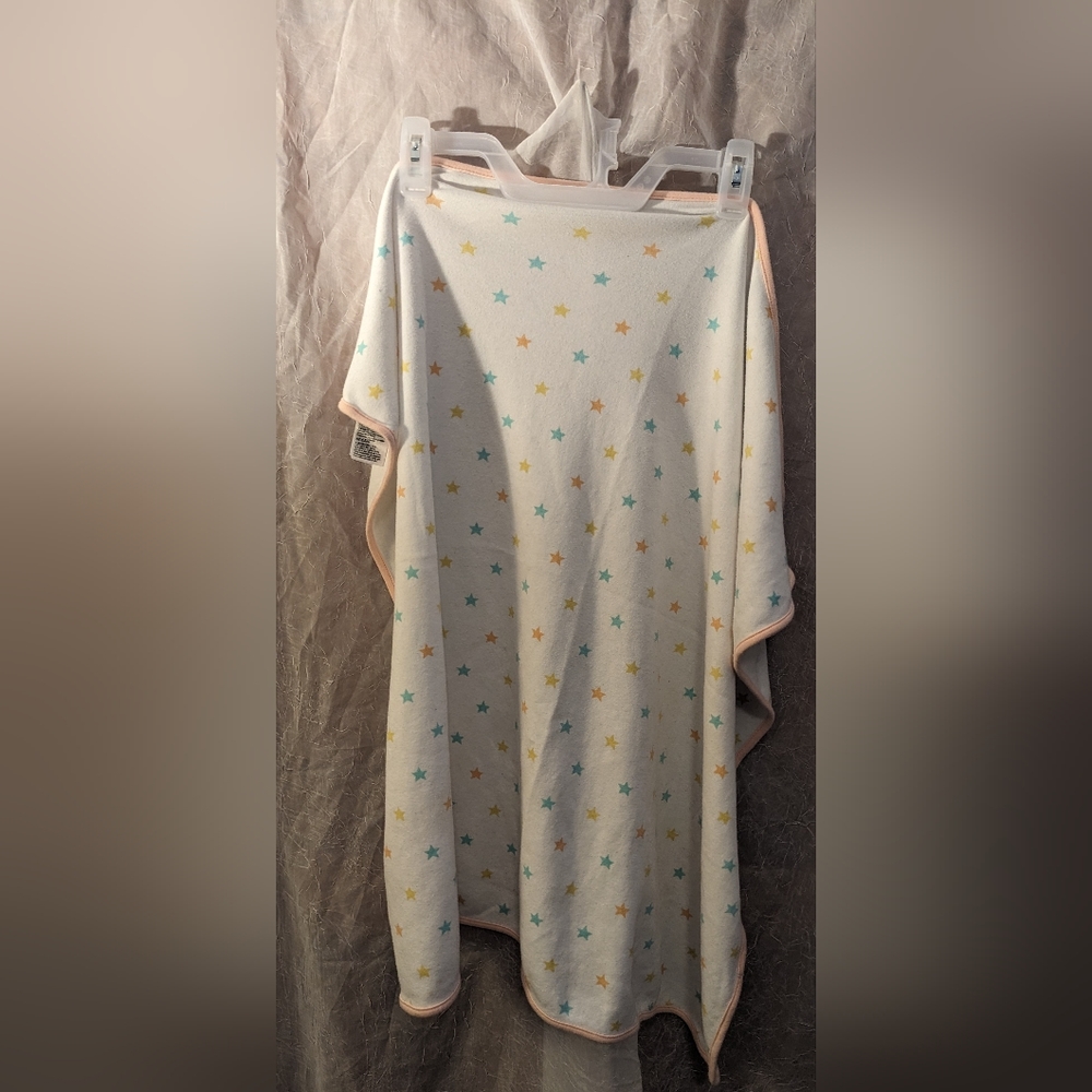 White swaddle blanket with orange, blue and yellow stars and pink border